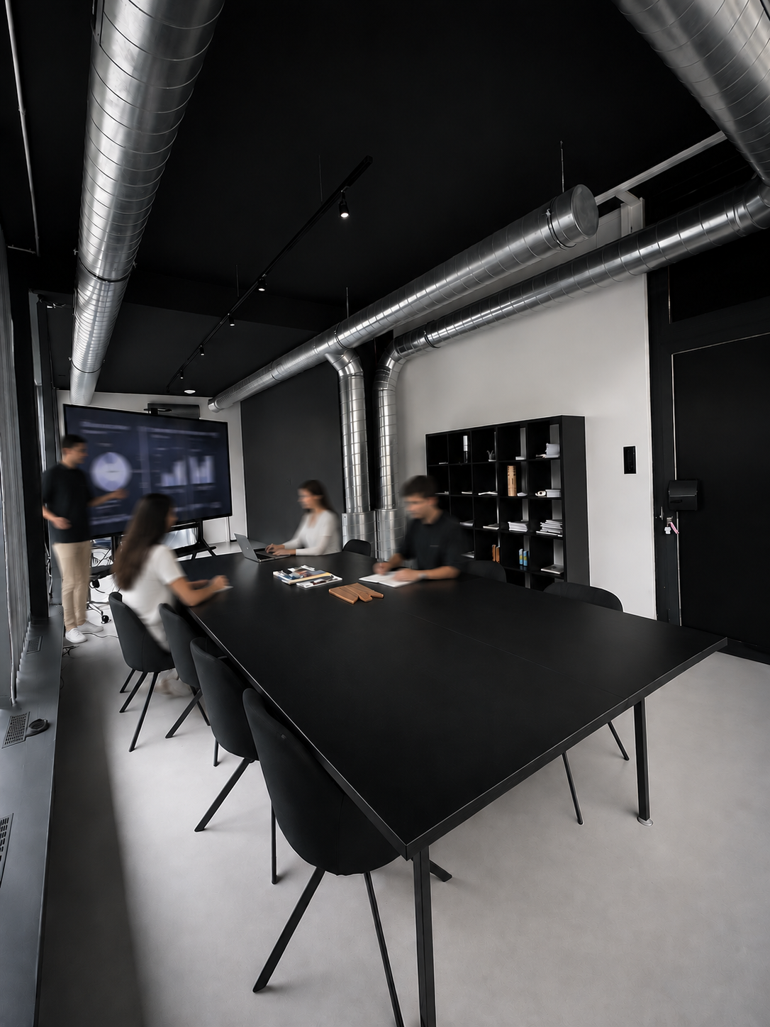 Team members working around a black conference table in a modern meeting room